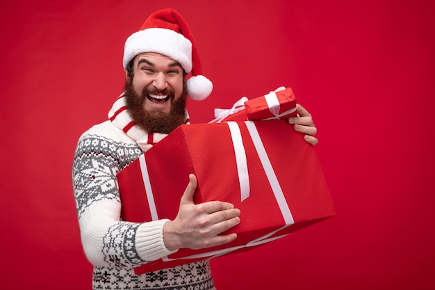 barbu, dans, chapeau noël, sourire, et, tenue, tas, de, coffrets cadeaux