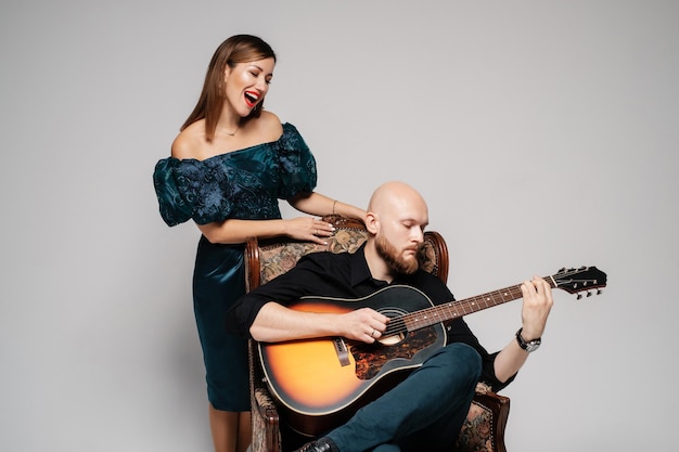 Un barbu joue de la guitare La femme chante une chanson Duo acoustique