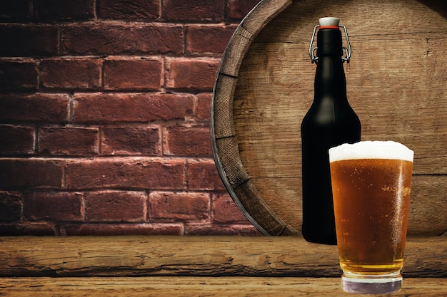 Un baril de bois et un verre de bière sur une vieille table en chêne