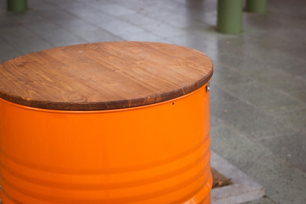 Un baril orange avec un dessus de table en bois