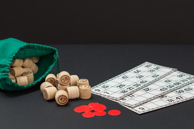 Barils de loto en bois avec cartes de jeu de sac et jetons rouges