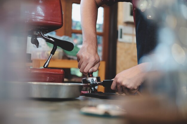 Barista en appuyant sur le café dans le porte-machine.