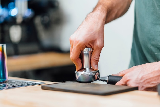 Barista en appuyant sur le café pour le porte-filtre