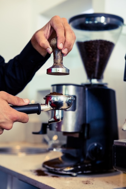 Barista appuyant sur les marcs de café frais