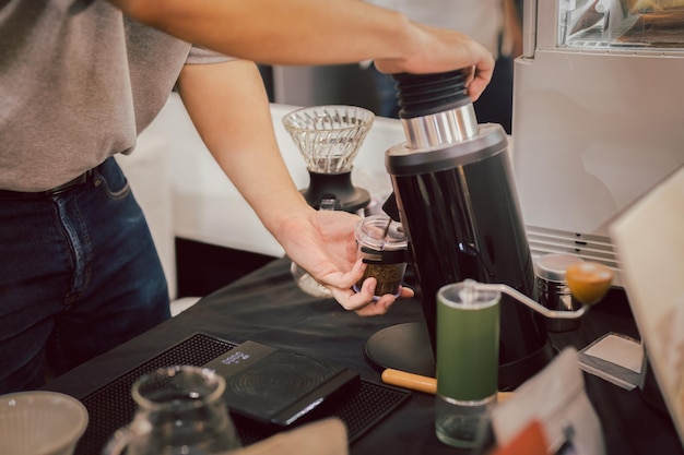 Barista broyant des grains de café dans un café