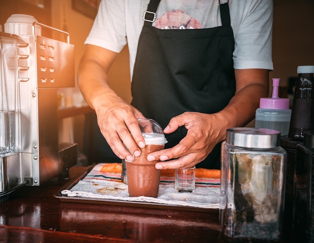Photo barista de café d'affaires tenant un liquide brun