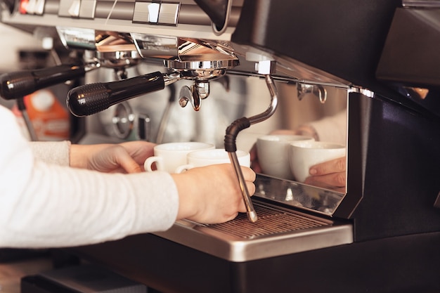 Barista, café, préparation du café, concept de préparation et de service. Mains féminines au travail