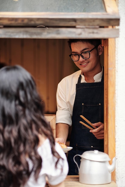 Photo barista donnant la commande au client