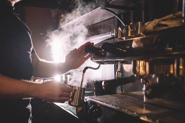 Barista faire mousser du lait avec la machine à café Le concept de bonne préparation du café