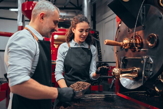 Barista faisant vérifier la qualité des grains de café torréfiés par le gestionnaire Les grains de café torréfiés sont classés