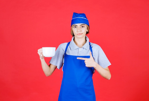 Barista féminin tenant une grande tasse blanche