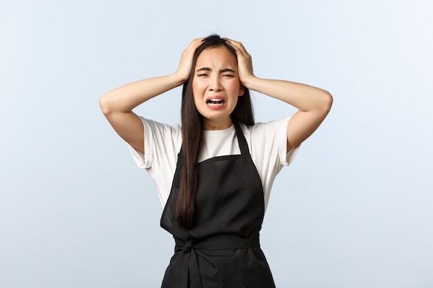 Barista femme triste dans un tablier noir