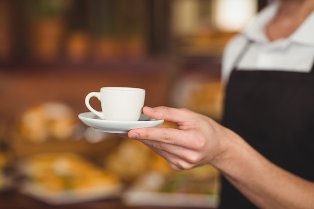 Barista offrant une tasse de café