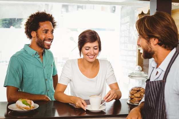 Barista parle avec deux clients