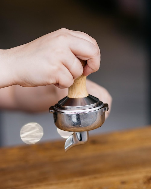 Barista avec port filtre et tamper à expresso Barista utilisant un tamper pour presser le café moulu dans un porte-filtre