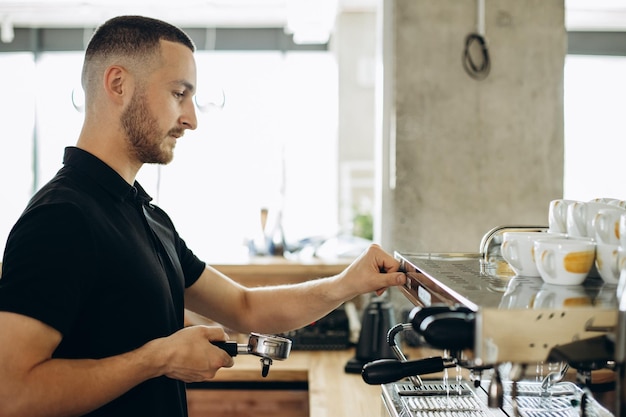 Barista préparant du café à la machine à café et tenant un porte-filtre