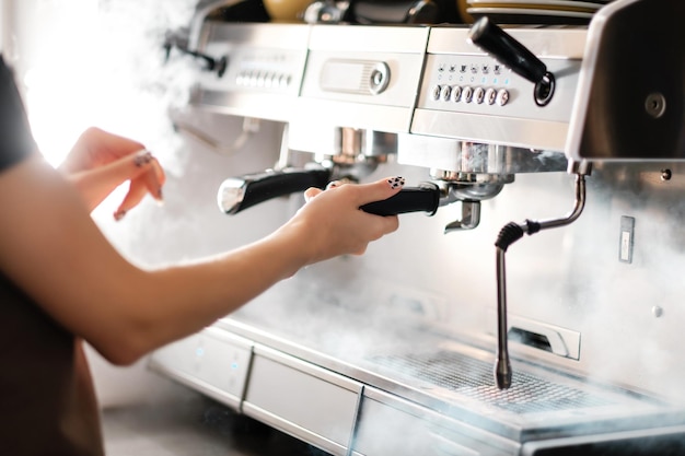 Barista prépare un cappuccino à l'aide d'une machine à café