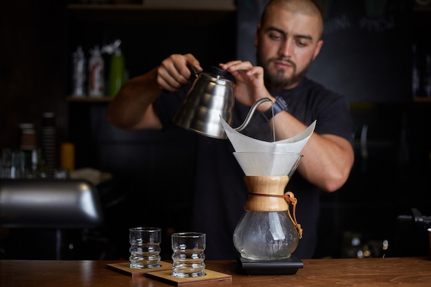 Barista prépare du café à l'aide de chemex versez sur une machine à café