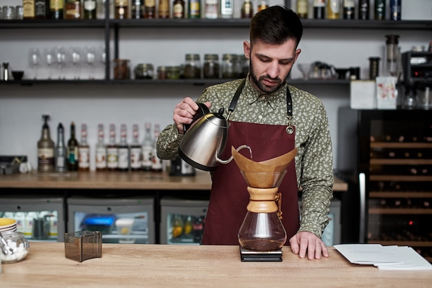 Barista professionnel préparant du café à l'aide de chemex versez sur une cafetière et une bouilloire. Autres façons de préparer du café. Concept de café.