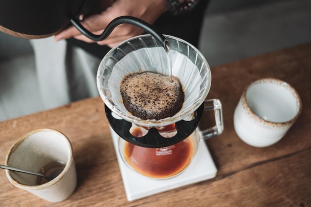 Photo barista qui coule du café et du café lent dans le style d'un bar