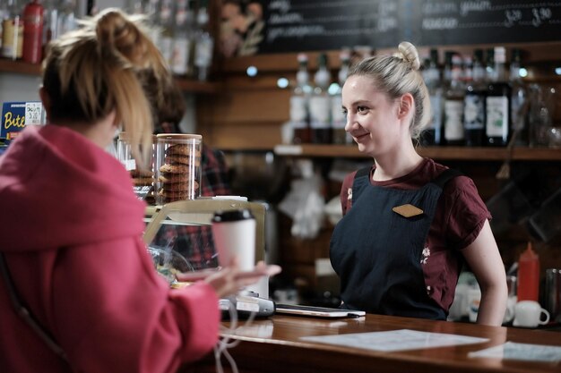 Barista sert une jeune fille au comptoir d'un café.