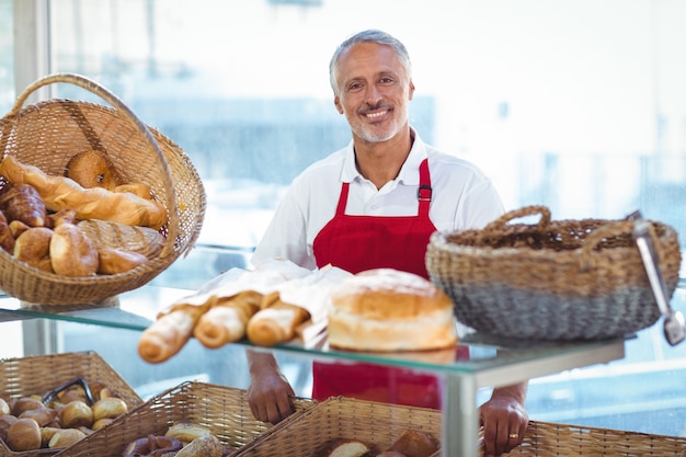 Barista souriant à la caméra derrière le comptoir