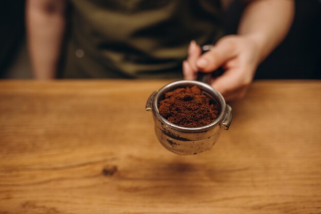 Barista tempérant le café moulu dans un pichet à expresso