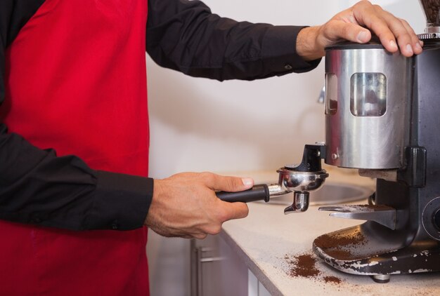 Barista utilisant un moulin à café pour moudre des grains de café