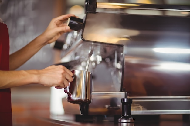 Barista à la vapeur de lait à la machine à café