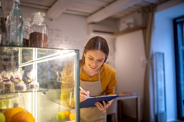 Un barista vérifiant les desserts dans la vitrine