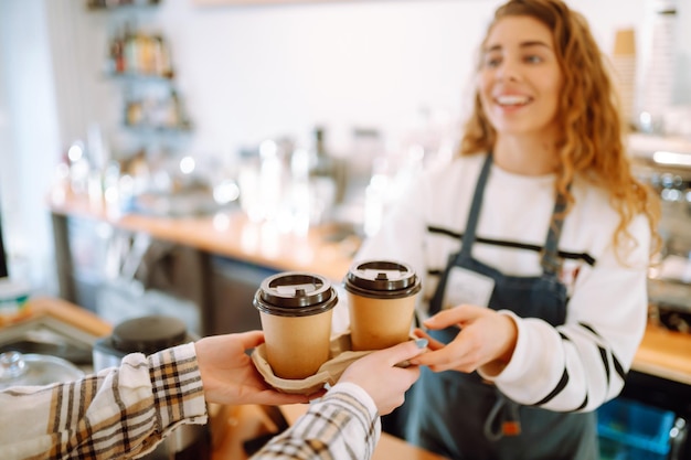 Bariste dans un café qui tient du café à emporter et de la nourriture à emporter