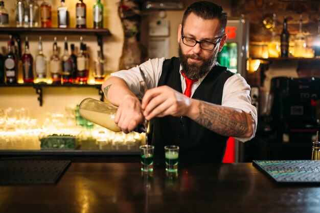 Barkeeper verser une boisson alcoolisée en verre