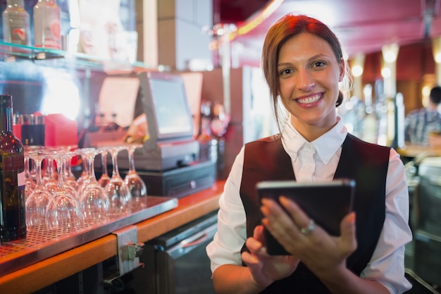 Barmaid focalisée utilisant l&#39;écran tactile jusqu&#39;à