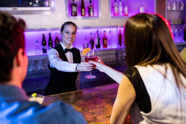 Barmaid servant une boisson à une femme