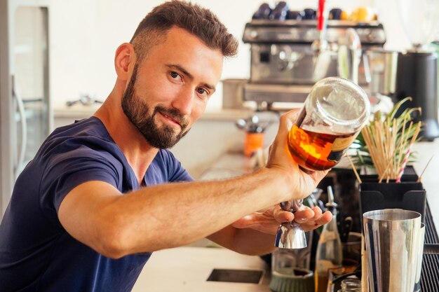 Barman arabe faisant un cocktail frais pour dame