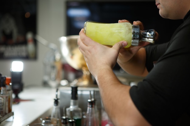 Barman au travail préparant des cocktails. Shaker à cocktail.