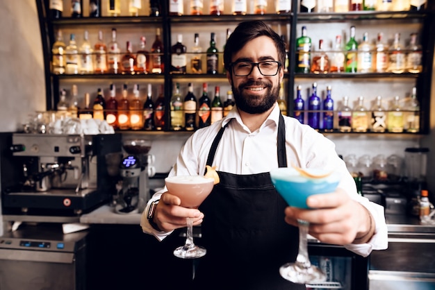 Le barman à la barbe prépara un cocktail au bar.