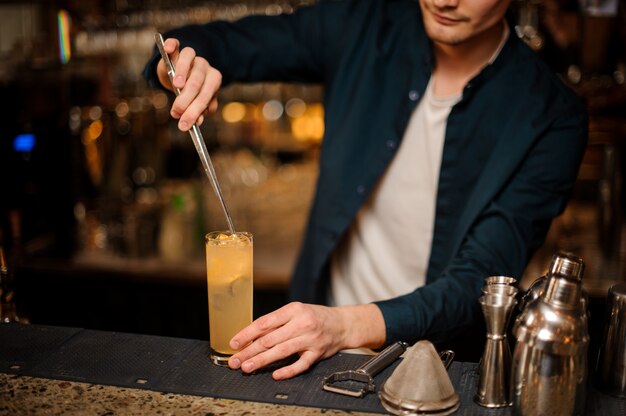 Le barman Brunet ajoute un décor pour une boisson alcoolisée