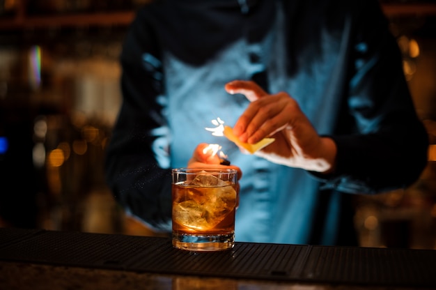 Barman Brunet servant un cocktail alcoolisé frais avec une note fumée