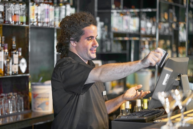 Le barman à la caisse