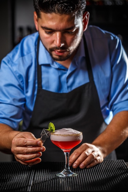 Le barman décore le cocktail