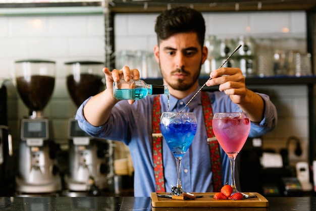 Un barman expert prépare un cocktail dans une boîte de nuit.