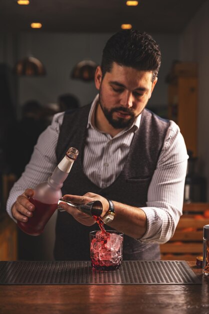 Photo un barman expert versant un cocktail au bar.