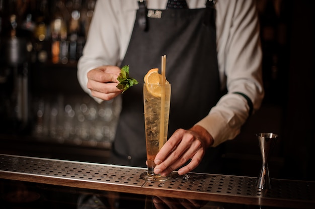 Barman faisant un cocktail frais au bar