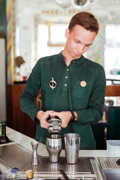 Barman faisant un cocktail, pressant le jus dans un shaker