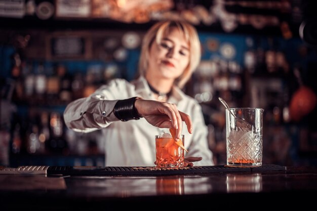 Le barman de fille concocte un cocktail à la brasserie