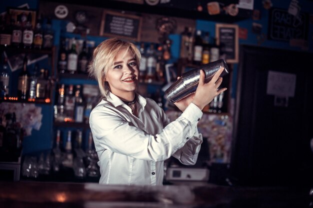 Barman fille mélange un cocktail dans le beerhall