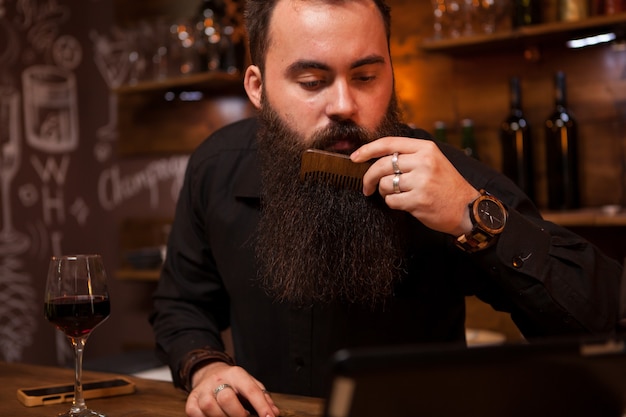 Barman hipster prenant soin de sa longue barbe. Grande Barbe.