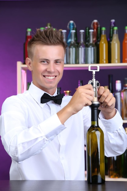 Le barman ouvre une bouteille de vin