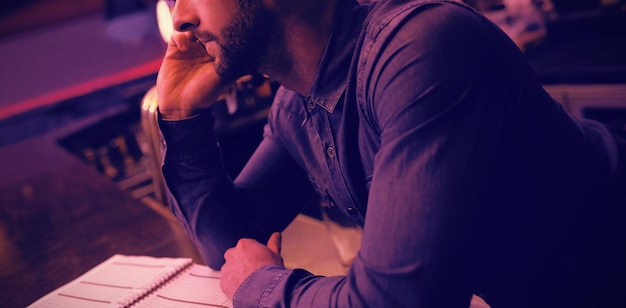 Barman parlant au téléphone portable au comptoir